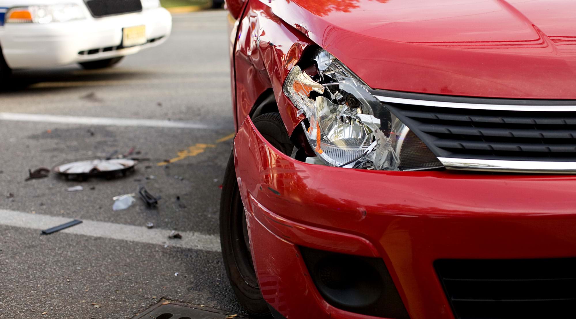 A red car crushed at the front from a road crash.